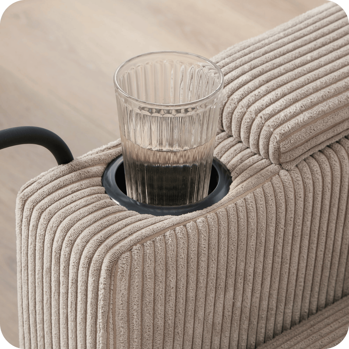 Cup holder ring in the armrest of the corduroy chaise lounge chair (close-up detail)
