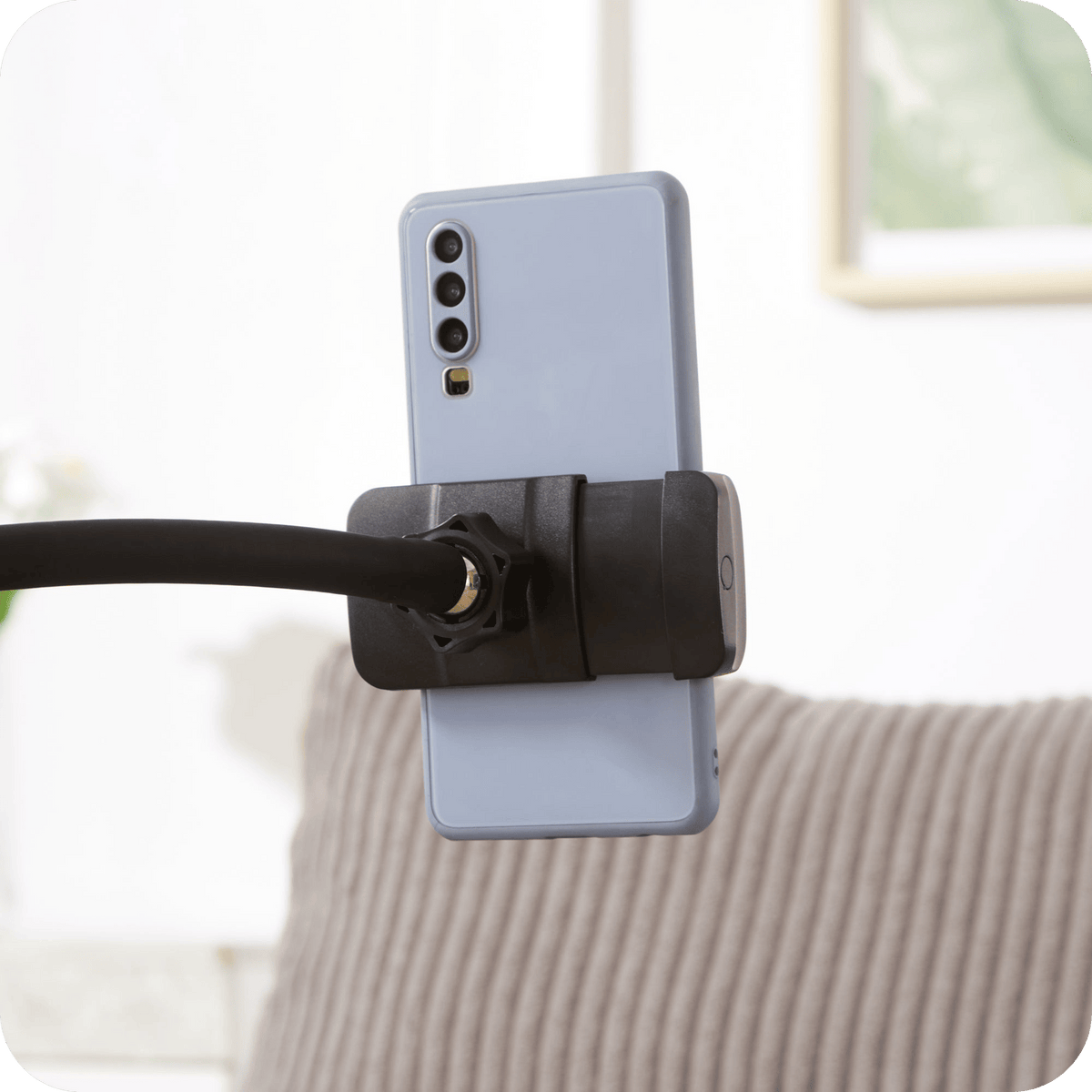 Flexible gooseneck phone holder on the corduroy chaise lounge chair (close-up detail)