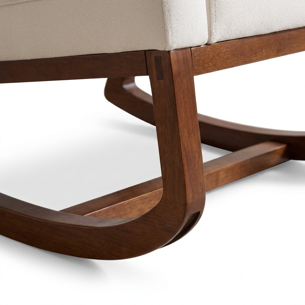 Walnut rocker runner joining the seat rail beneath the cream cushion of the Adirondack rocking chair (close-up detail)