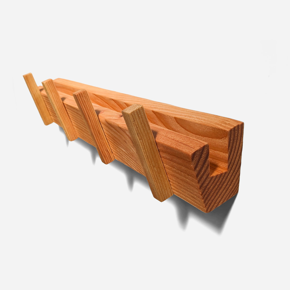 Wooden wall coat rack in reclaimed fir, four angled pegs and a mail slot along the top, angled view