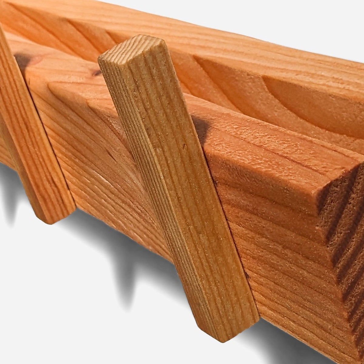 One flat wooden peg tilted up from the board face, grain visible behind it (close-up detail)