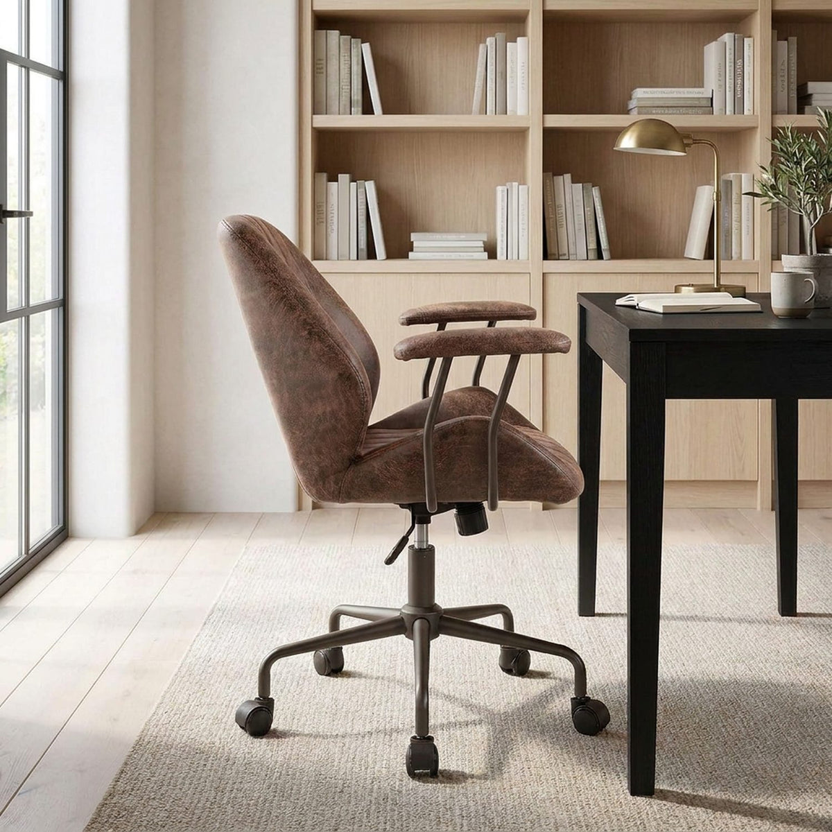 Desk chair in side profile at a writing desk in a home library, morning light