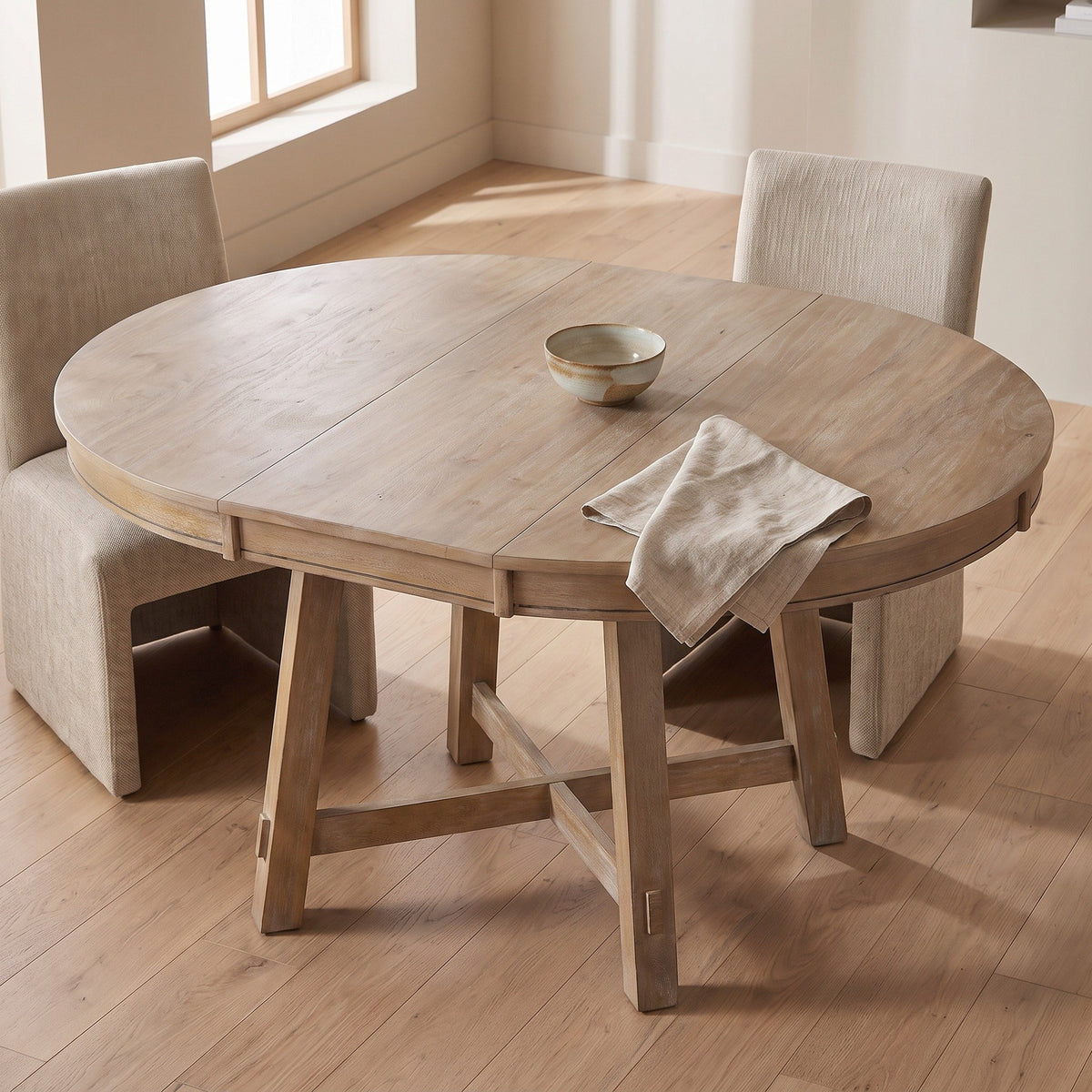 Light wood round table with linen chairs seen from above in a sunlit room
