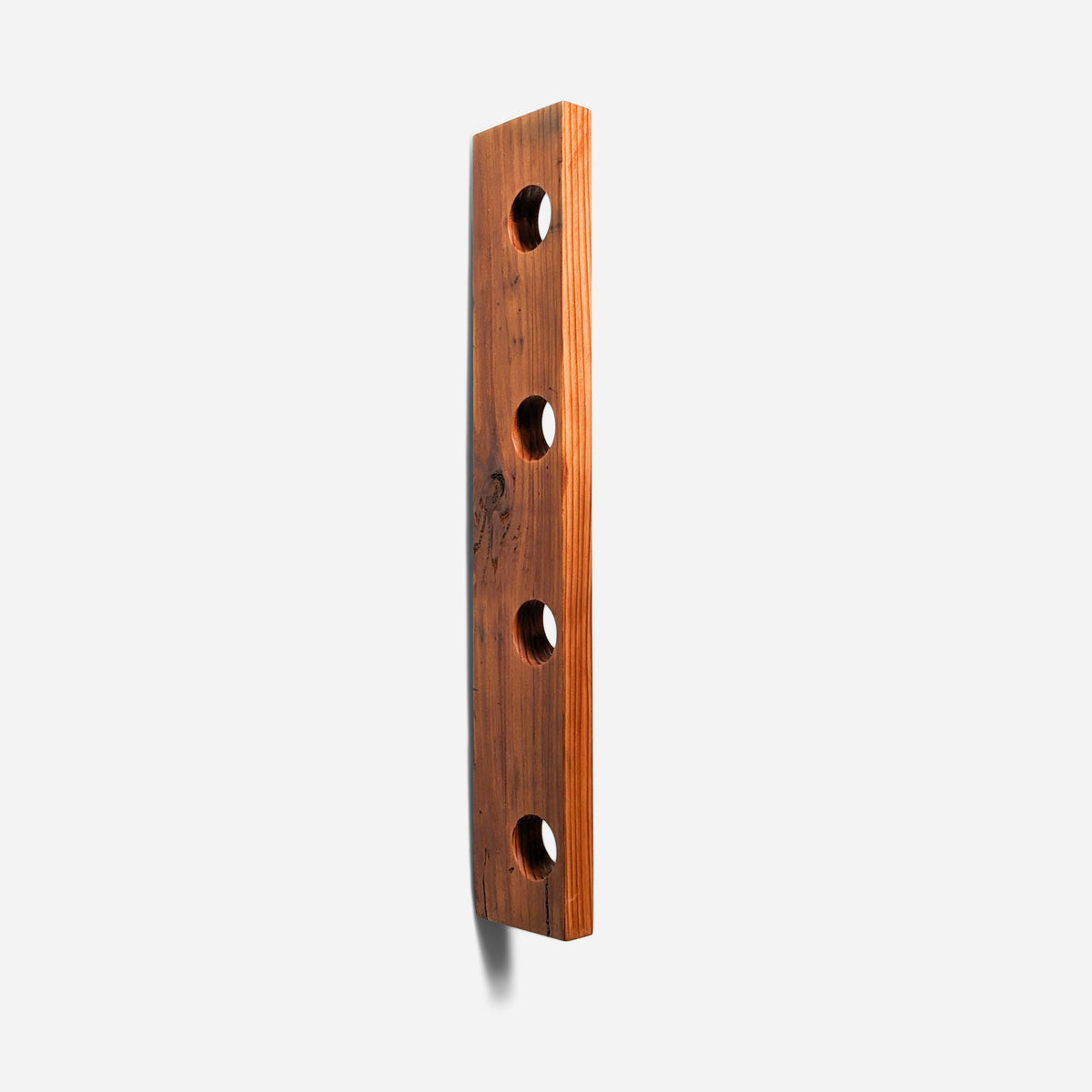 Floating bottle shelf in reclaimed fir with four bored holes, shown empty