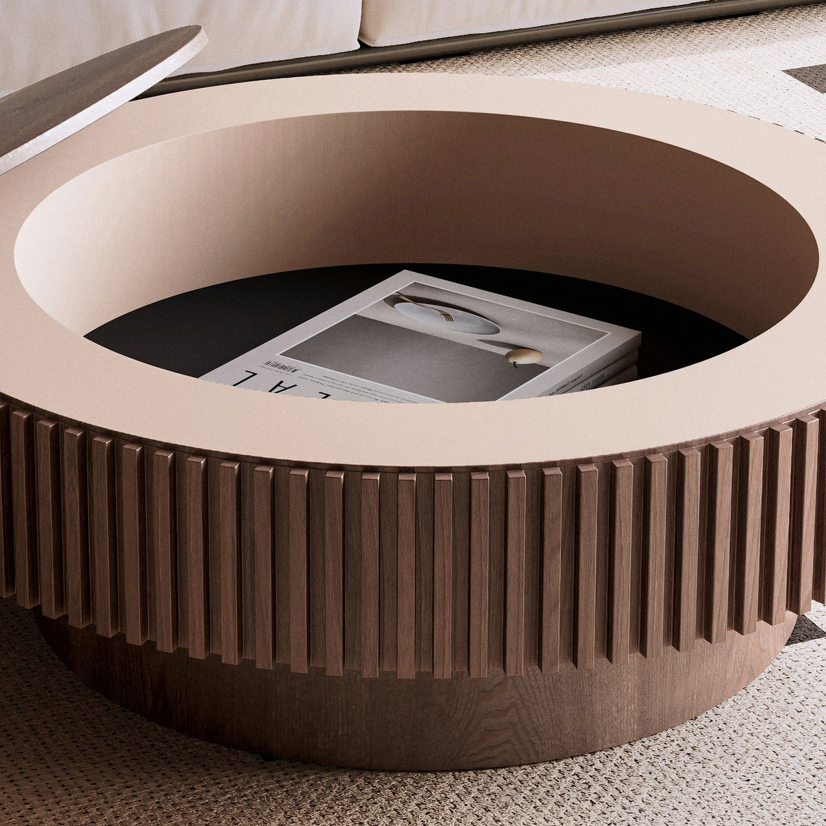 Lifted round top beside the blush-lined storage well holding a book, slatted band below (close-up detail)