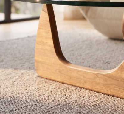 Environmental close-up of the walnut base of the glass-top coffee table in a living room setting