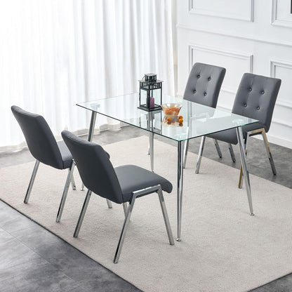 Dark tufted chairs and a lantern centrepiece around the table in a pale panelled dining room