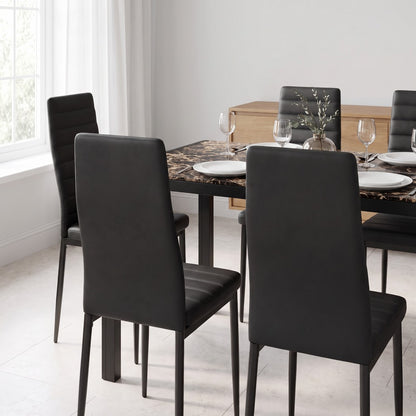 Marble-print glass dining table with tucked-in black chairs in a modern dining room
