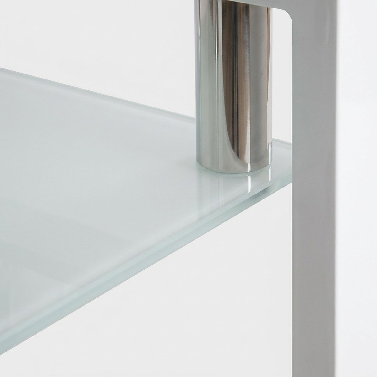 Close-up of the frosted tempered glass lower shelf corner beside a chrome post on a white frame