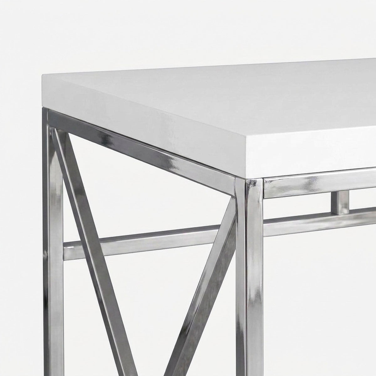 High-gloss white desktop corner meeting the chrome frame (close-up detail)