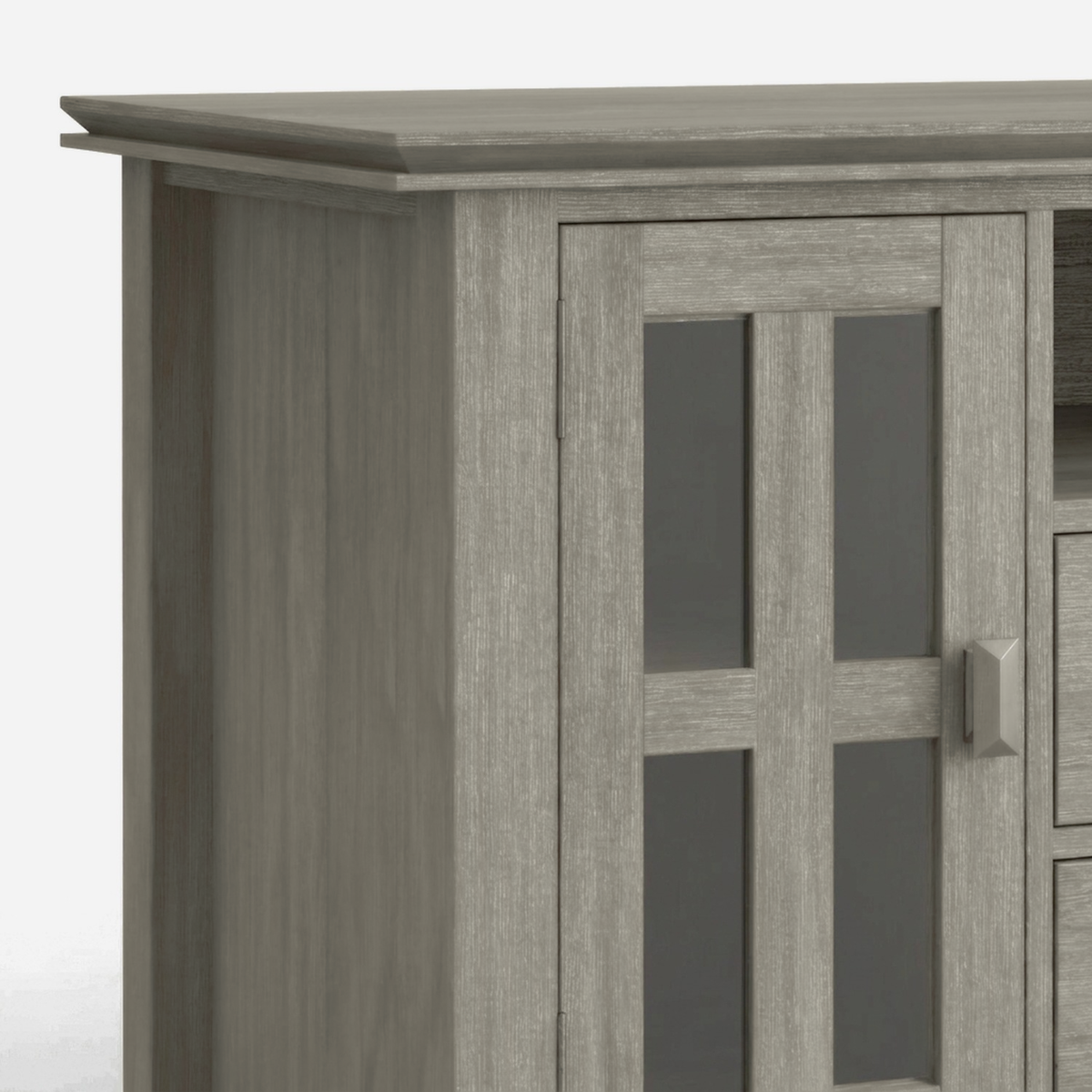 Tall glass-panel door with a bar pull and stepped top edge on the TV stand (close-up detail)