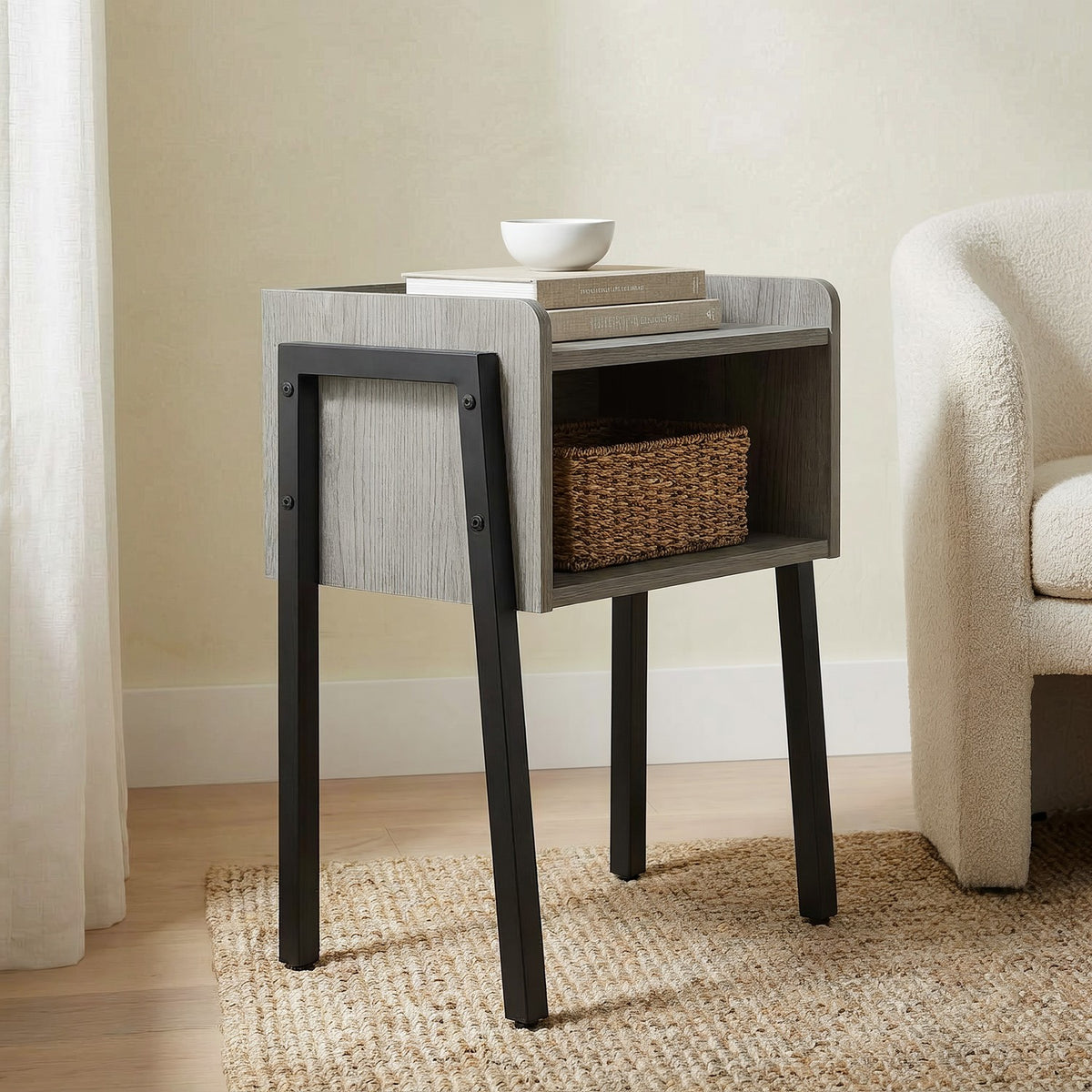 Grey table with black side frame seen close and low from the window side of the same reading nook