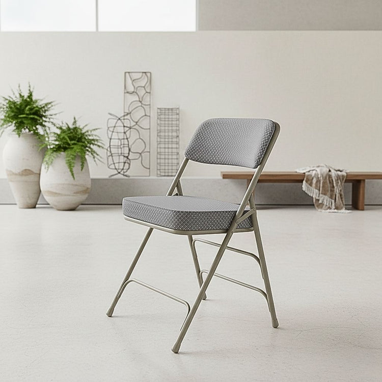 2-pack of Hercules series folding chairs with gray fabric cushioned seats and heavy-duty steel frames, ideal for high-capacity event seating.