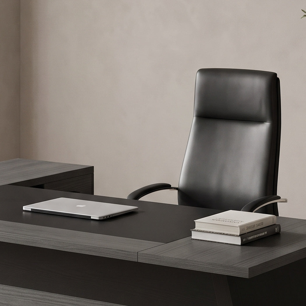 Close-up of the desk work surface with a laptop and books by a sheer-curtained window