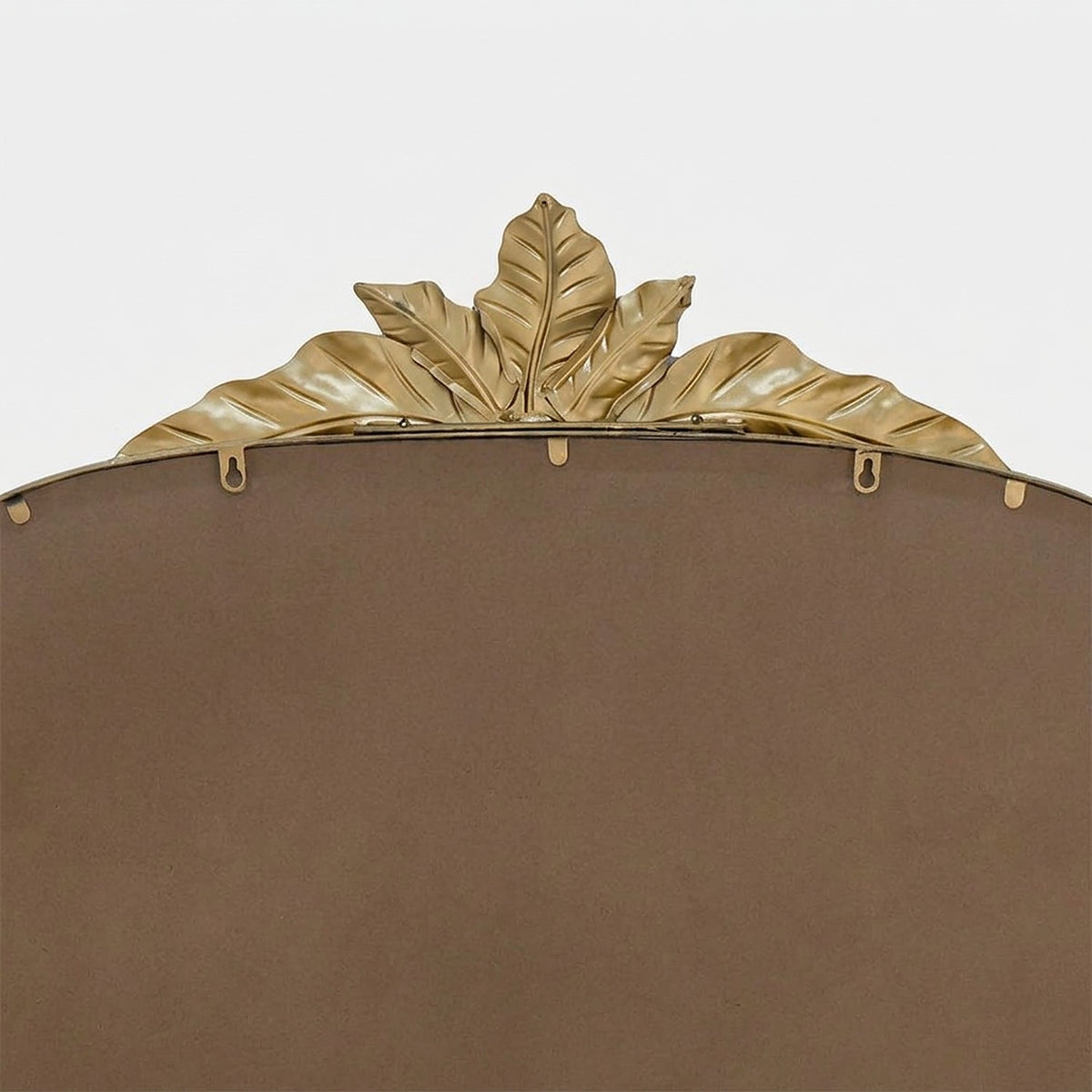 Back of the mirror with keyhole hanging tabs beneath the leaf crest, close-up detail