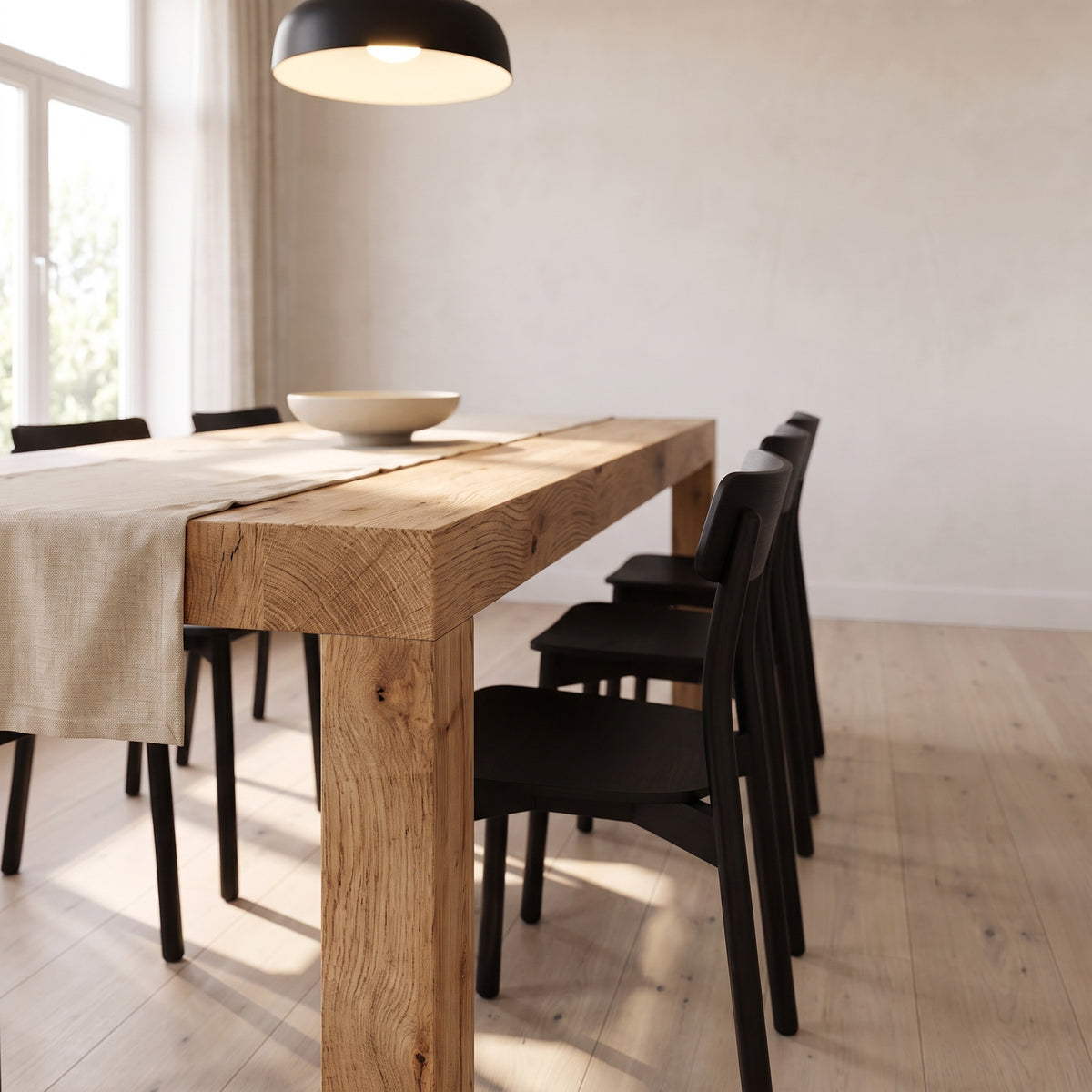 Low view along the extended table, the corner leg and thick top edge in warm afternoon light