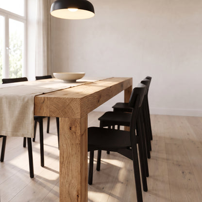 Low view along the extended table, the corner leg and thick top edge in warm afternoon light