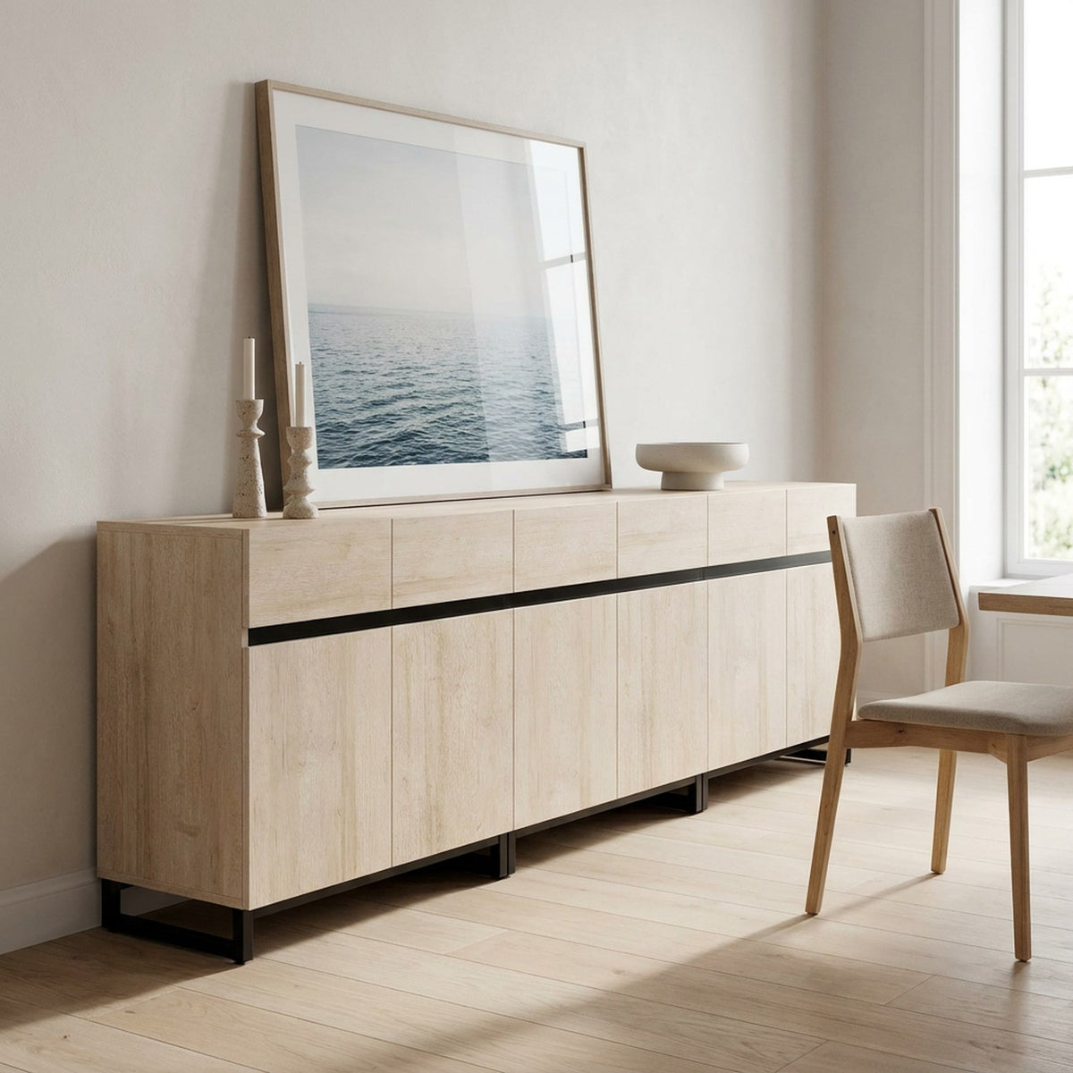 Light oak sideboard console in a dining hall with a framed seascape on top