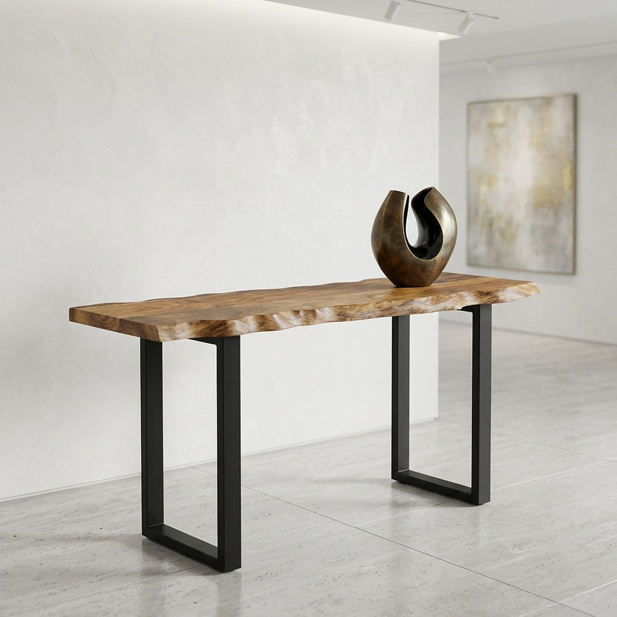 Acacia slab table on black steel legs in a bright gallery entry with a bronze sculpture and an abstract canvas