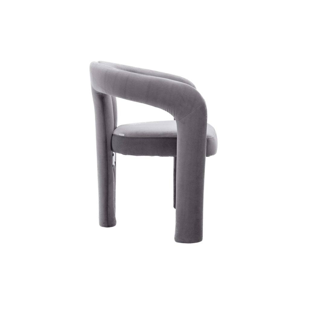 Velvet dining armchair with curved back and plush grey upholstery.