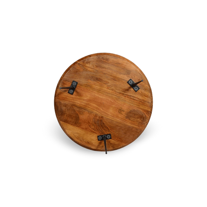 Top-down detail view of the organic wood grain on a round mango wood coffee table with industrial metal legs.