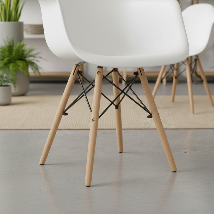 Set of 2 mid-century modern white molded dining armchairs with light wood legs and black metal cross supports.