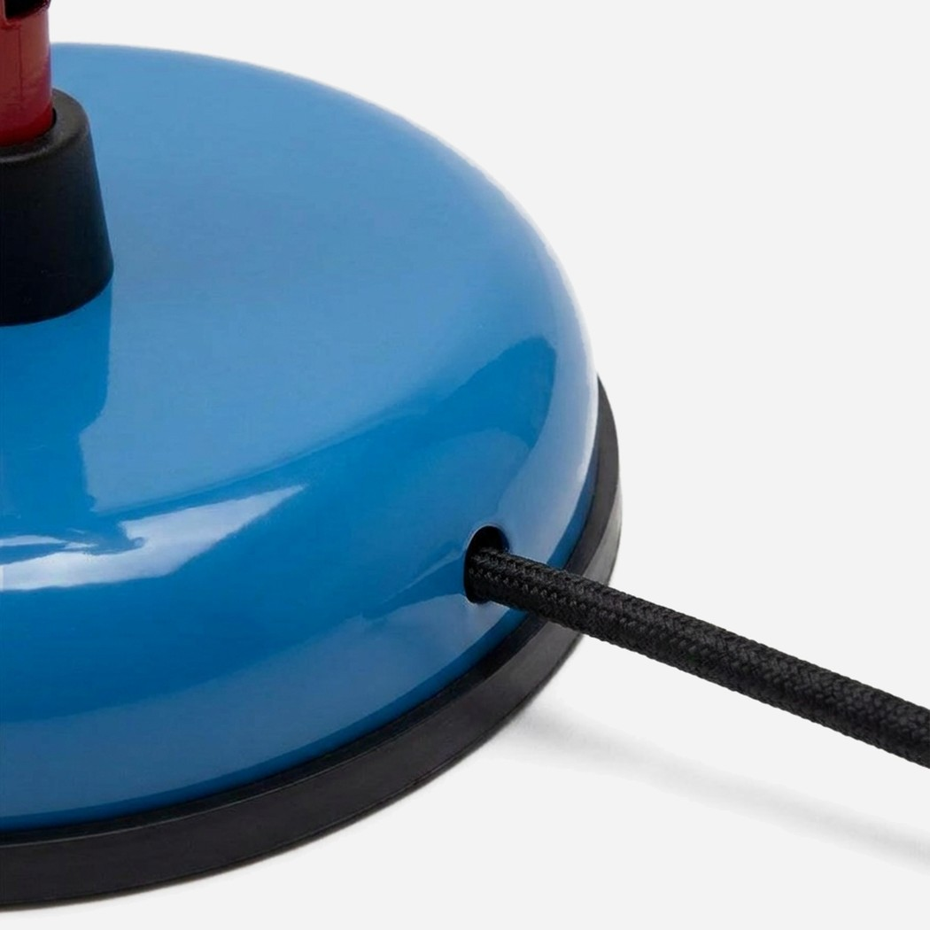 Close-up detail of the cord exit through the weighted base — ships on flat #F3F3F3, not transparent: the close-up crops the product at the frame edge (close-up detail)