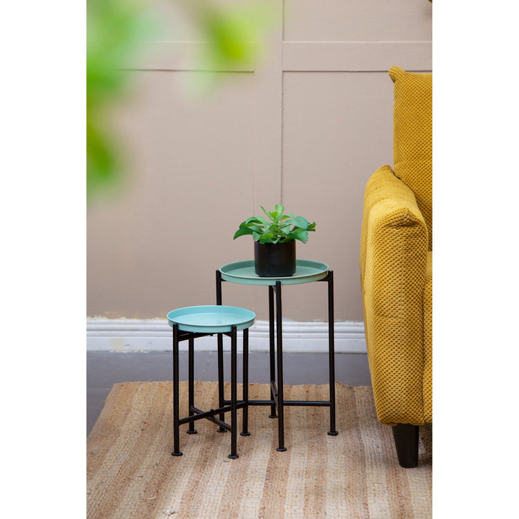 nesting tables with a plant on top in a living room setting.