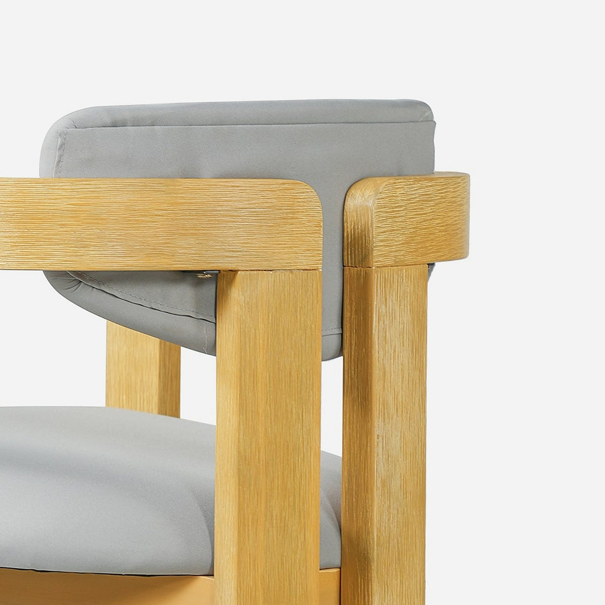 Rounded acacia armrest corner meeting a flat slab leg, open wood grain (close-up detail)
