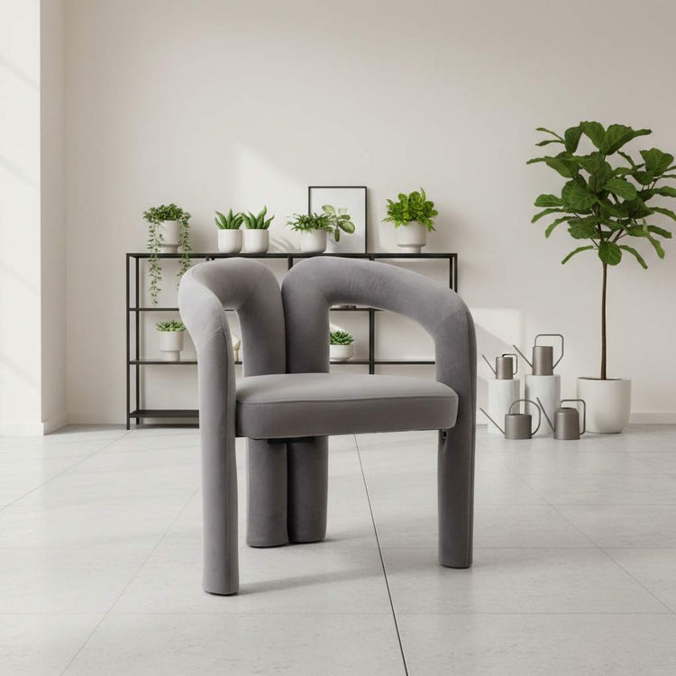 Gray velvet dining armchair with curved back in a bright minimalist dining room.