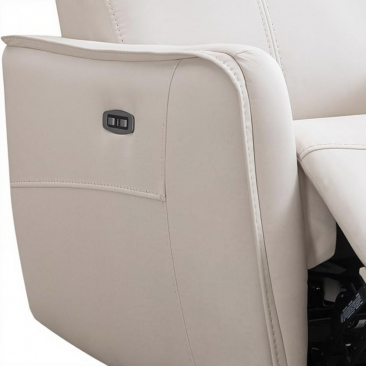 Push-button power recline control on the cream faux leather arm panel (close-up detail)