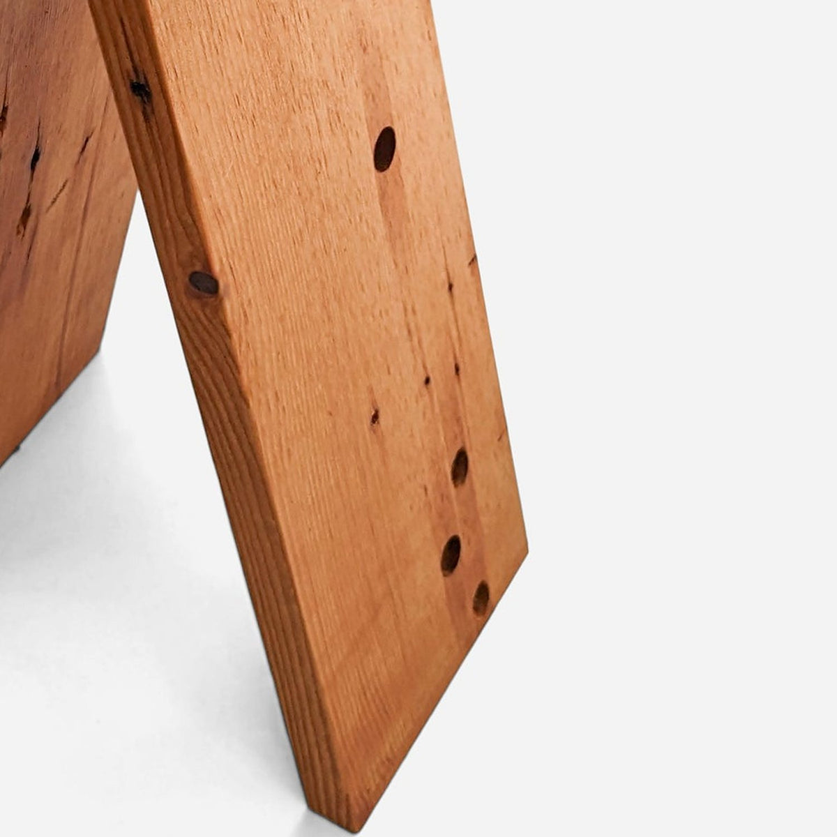 Fir plank leg with old nail holes from the wood's first life, close up