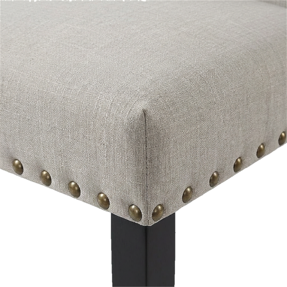 Close-up of a tan linen-cotton seat corner with brass nailheads above an espresso chair leg