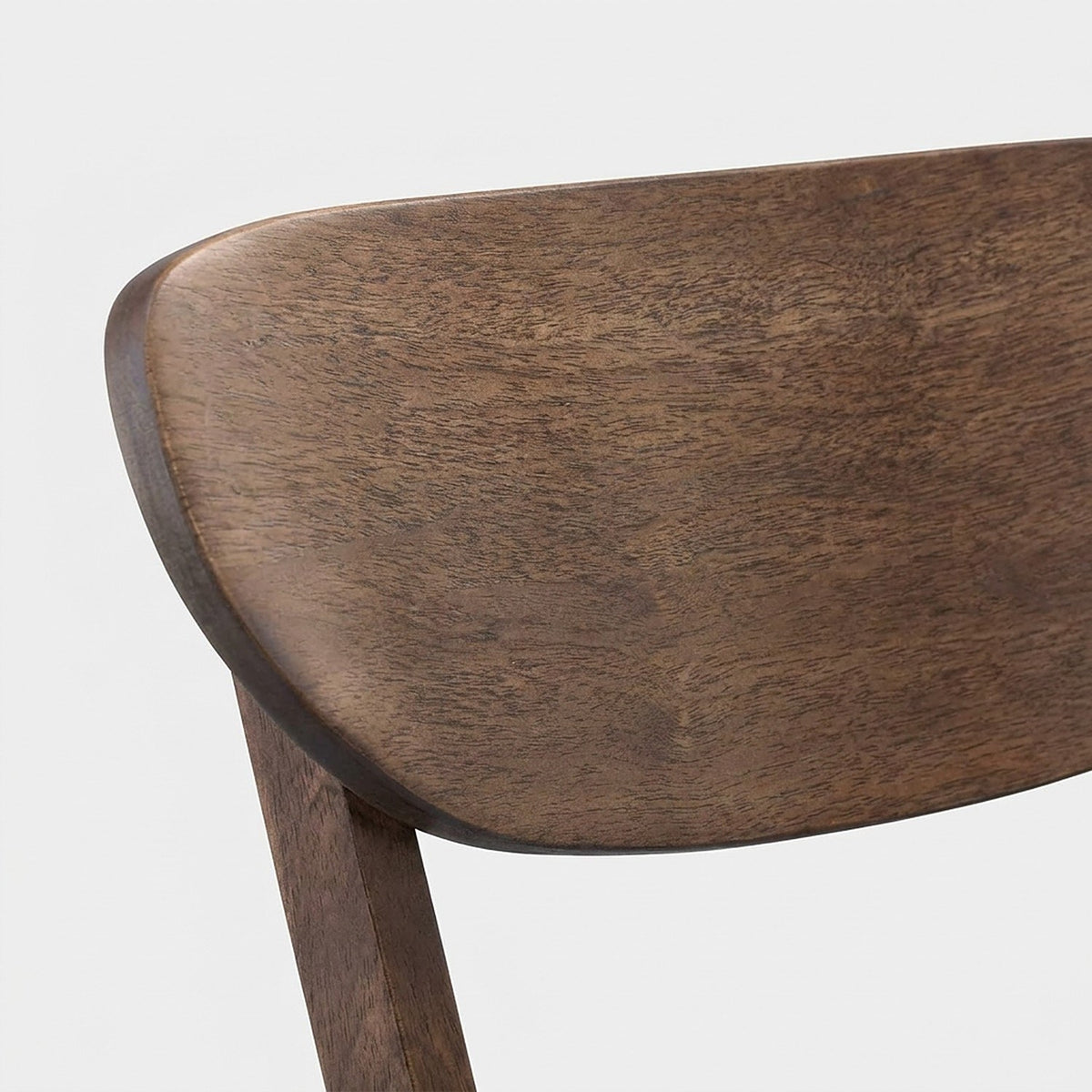 Close-up of the curved walnut chair backrest and its grain