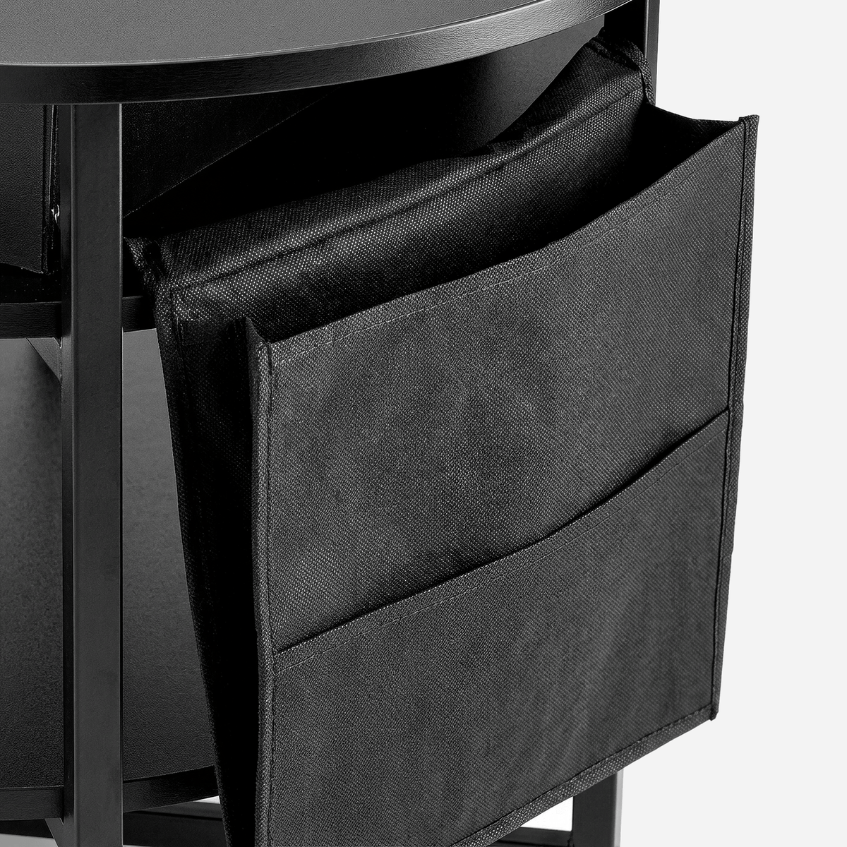 Black fabric side pocket with two stacked pouches hanging from a round lift-top coffee table (close-up detail)