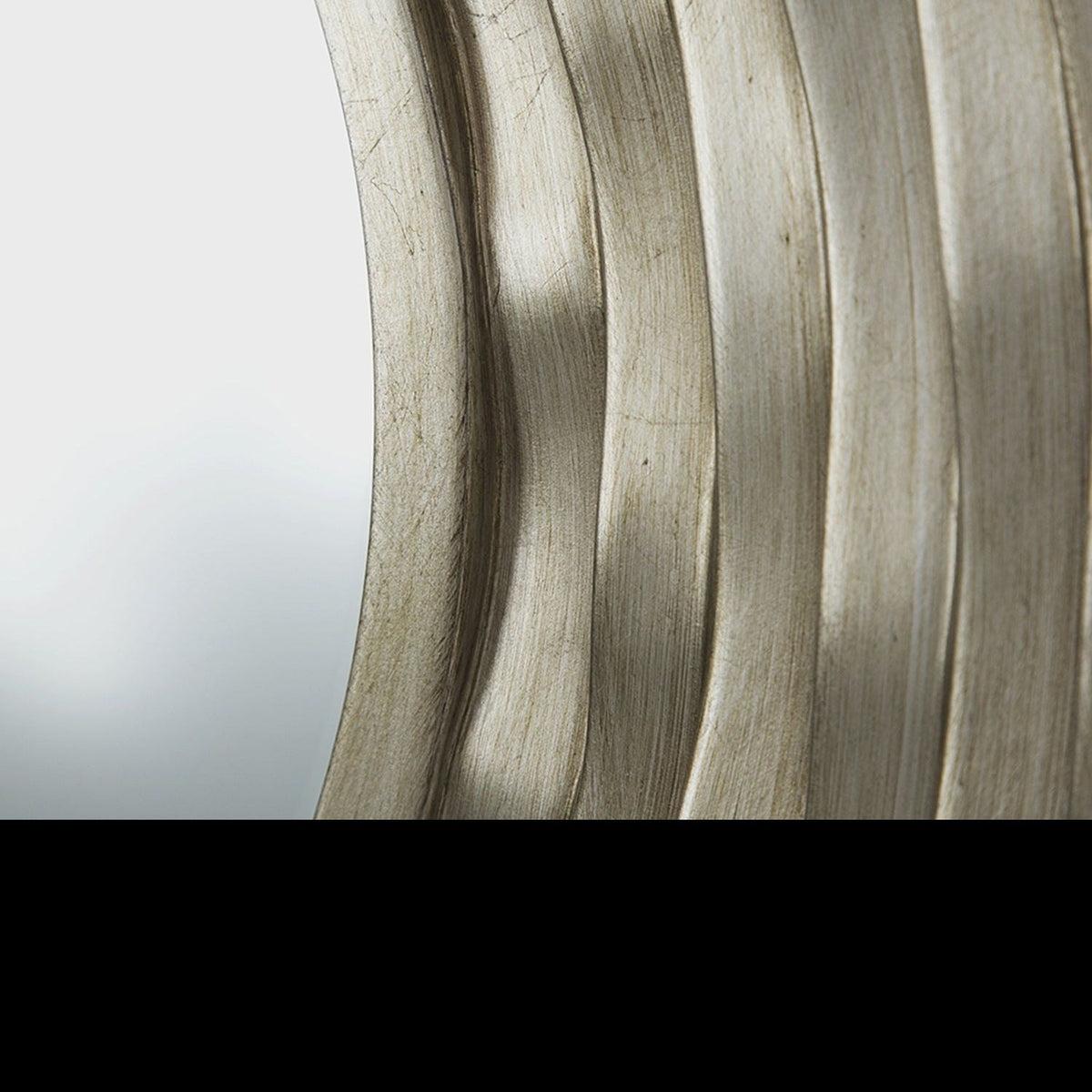 Close-up of the rippled ring relief on a silver wall mirror frame