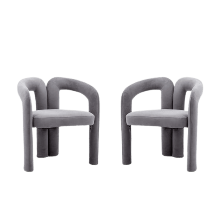 Pair of plush gray velvet dining armchairs with curved backs and cushioned seats.