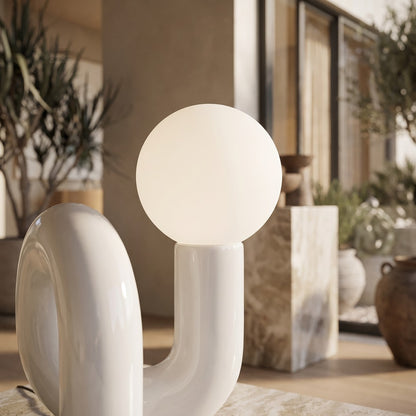 Glass globe to ceramic column junction in a styled interior setting (feature callout)