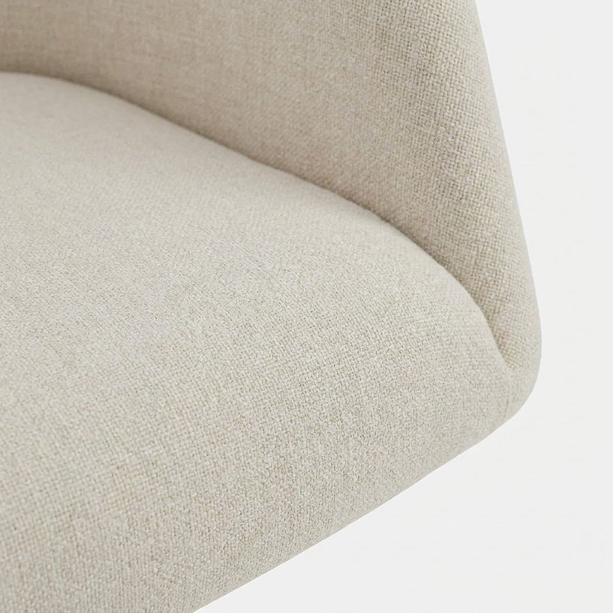 Fine woven cream upholstery and seam at the seat edge (close-up detail)