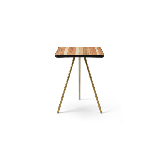 Tripod side table with a torched reclaimed-wood top and brass legs, front view