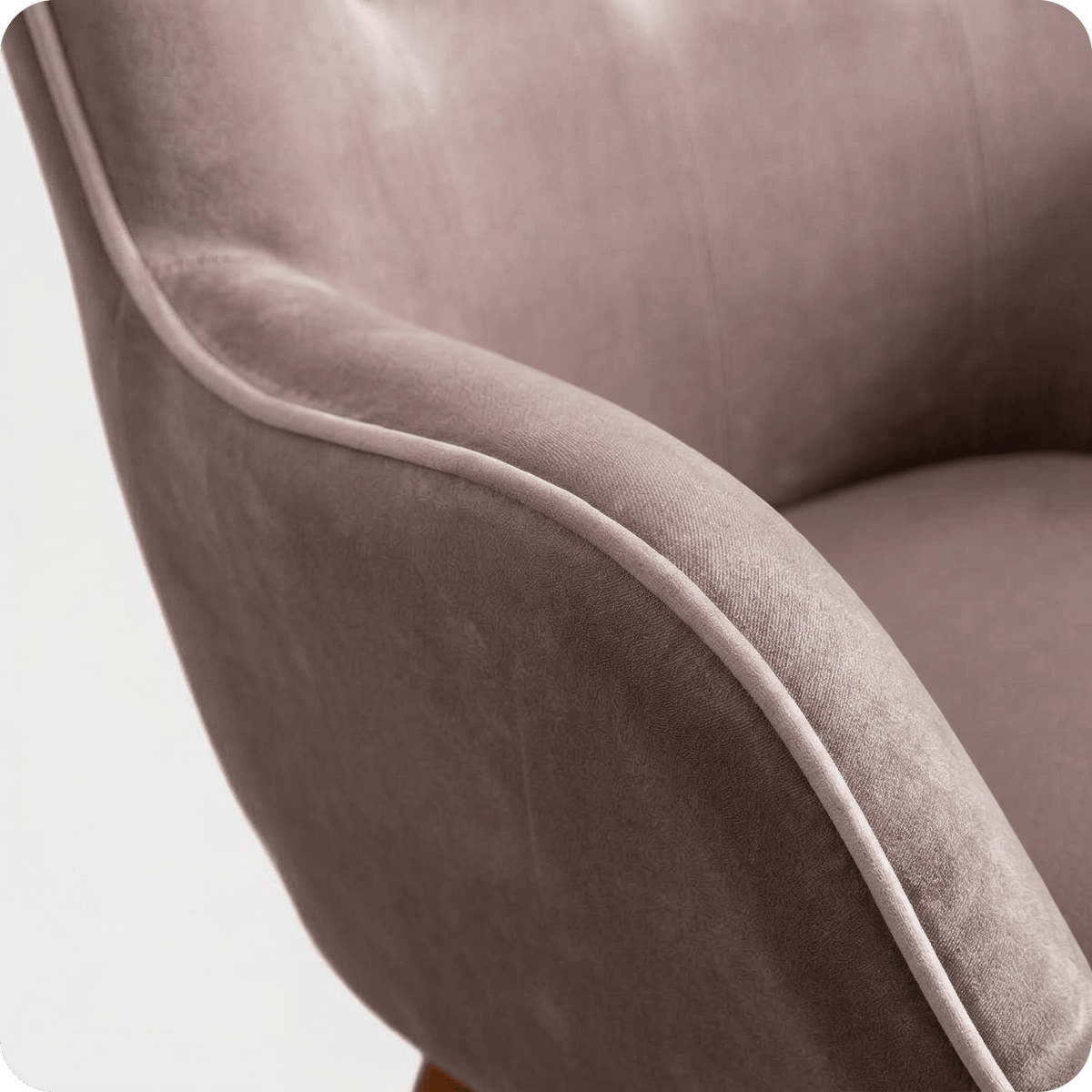 Curved piped velvet arm of the taupe wingback chair (close-up detail)