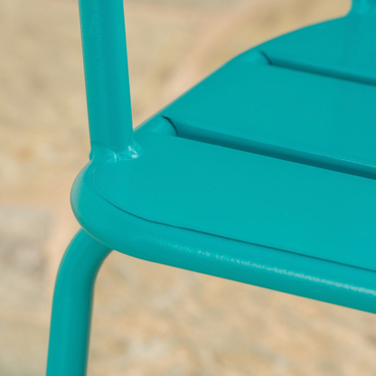 Weld where the teal chair leg meets the rolled seat edge (close-up detail)