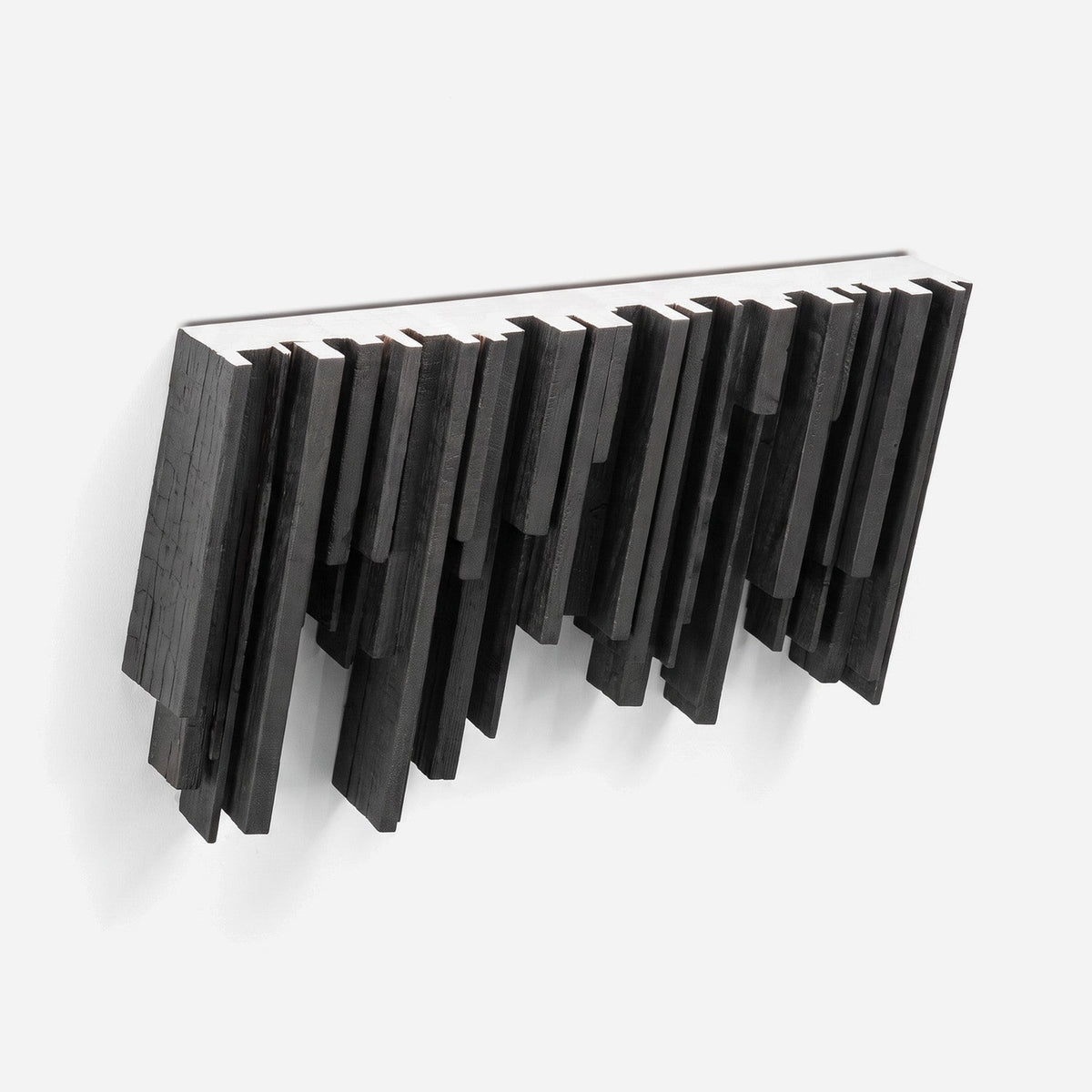 Floating wall shelf with black torched slats and a white stained top, angled view