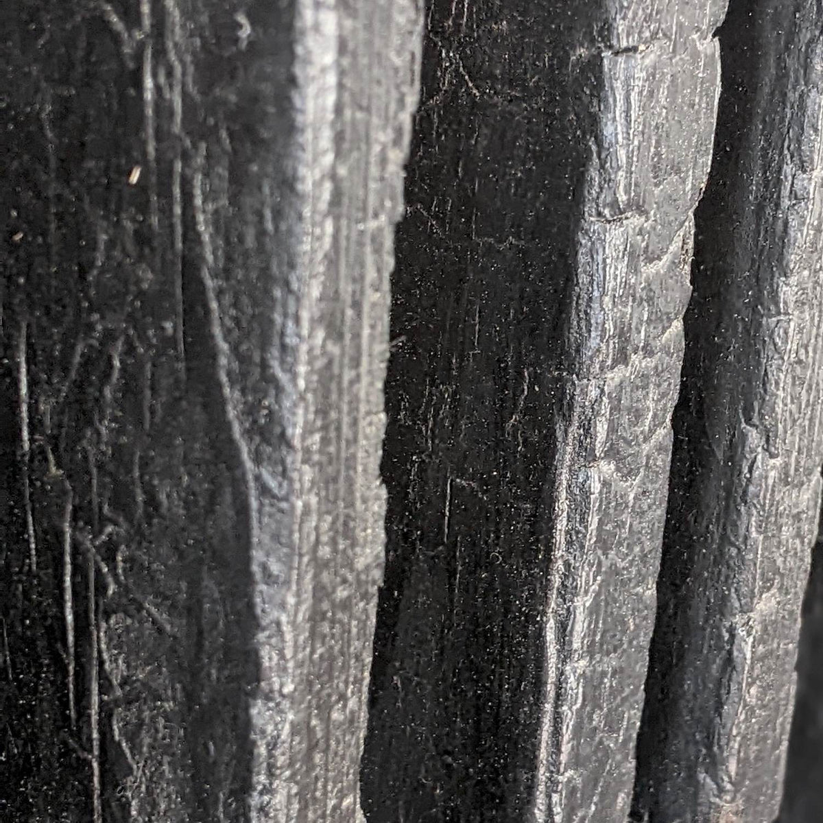 Close-up of cracked black alligator char on narrow torched slats