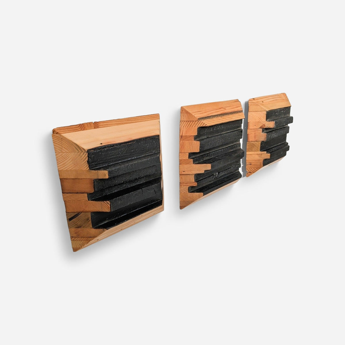 Three-panel wood wall sculpture with charred epoxy centres, angled view