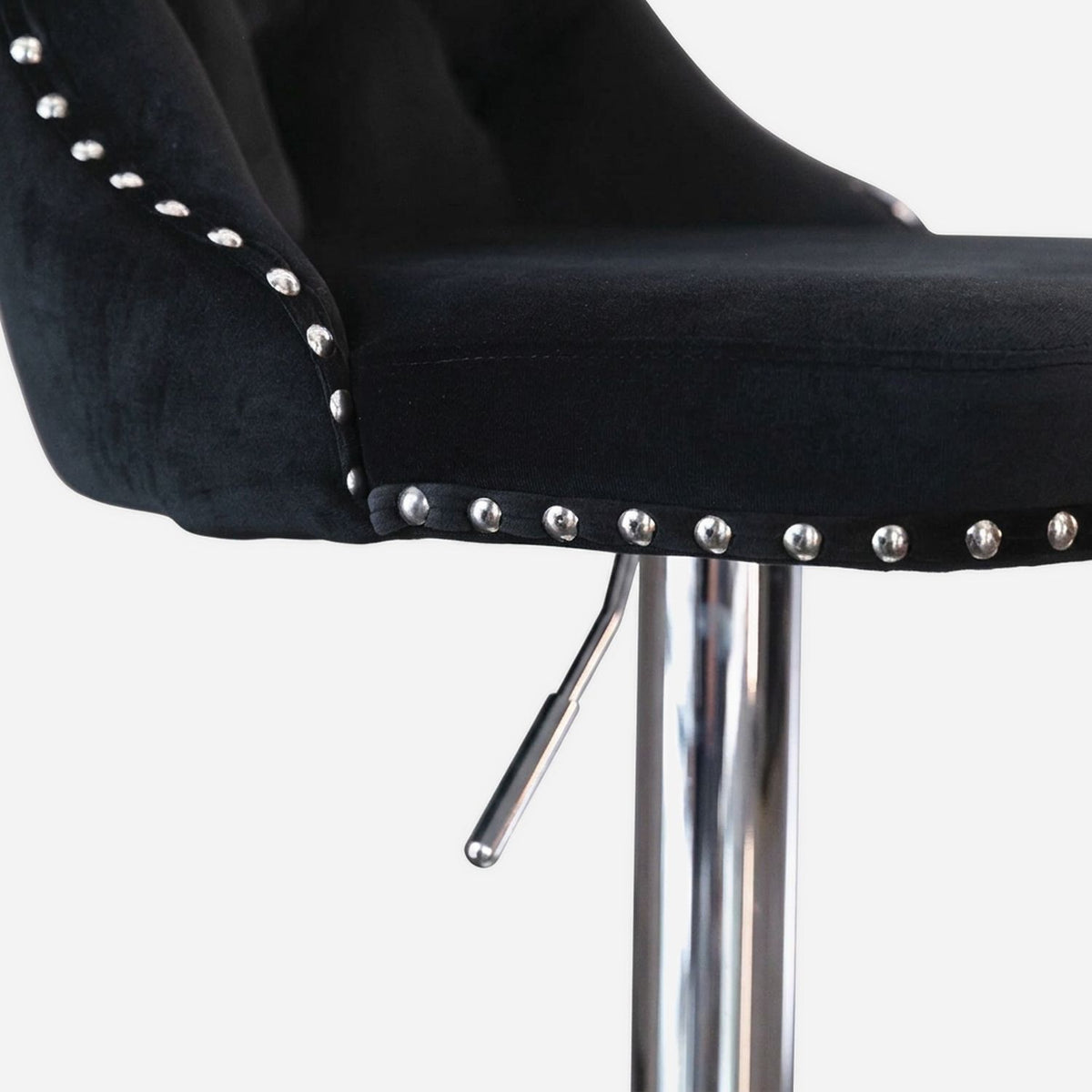 Seat edge with the gas-lift lever on the black velvet stool, close up