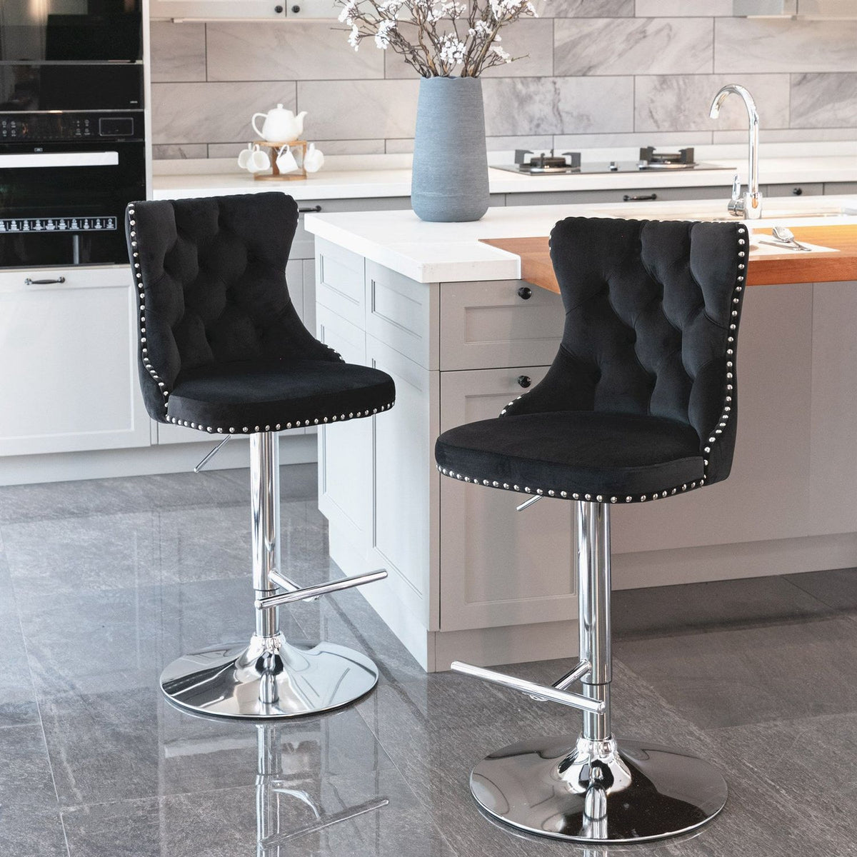 Two tufted velvet bar stools at a white shaker kitchen island, wide view