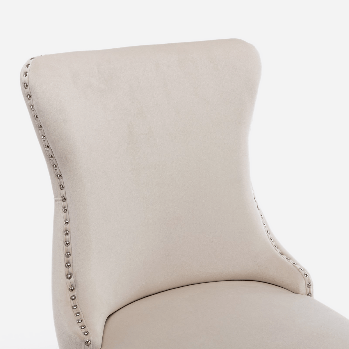 Flared wing of a velvet dining chair with silver nailhead trim (close-up detail)