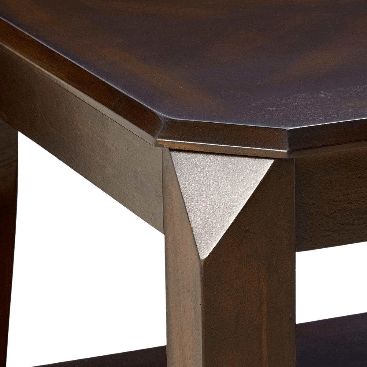 Close-up detail of a dark brown wooden table corner, showing the tabletop edge, leg, and a white triangular metal connector.