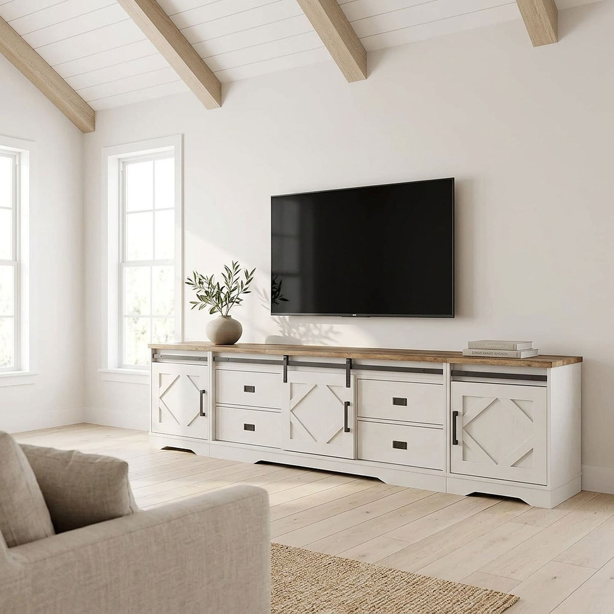 The three-piece white farmhouse TV stand on a long living room wall, wide view
